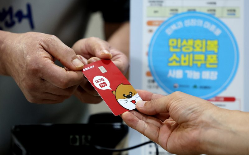 [대구=뉴시스] 이무열 기자 = 민생회복 소비쿠폰 신청 이틀째인 지난 22일 대구 중구 한 음식점에서 식사를 마친 시민이 소비쿠폰이 입금된 선불카드로 결제하고 있다. 2025.07.22. lmy@newsis.com