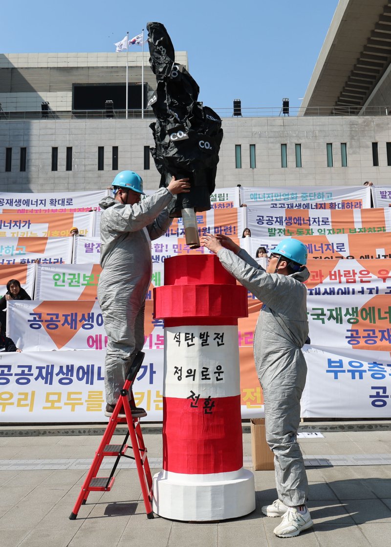 [서울=뉴시스] 권창회 기자 = 기후환경단체 회원들이 지난해 3월 공공재생에너지 선언 공동 기자회견에서 공공에너지 전환 촉구 퍼포먼스를 하고 있다. 2024.03.14. kch0523@newsis.com
