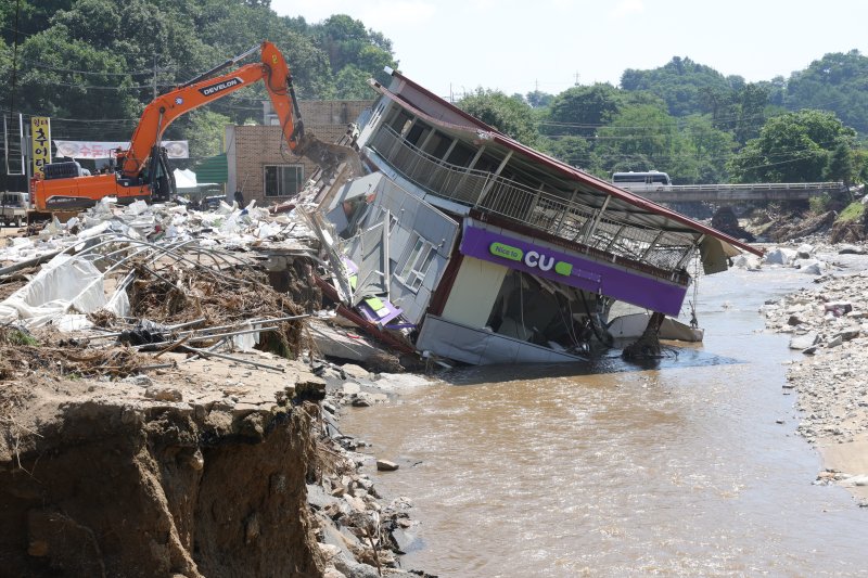 가평군 수해 현장에서 포클레인이 무너진 건물 잔해를 치우고 있다. 연합뉴스