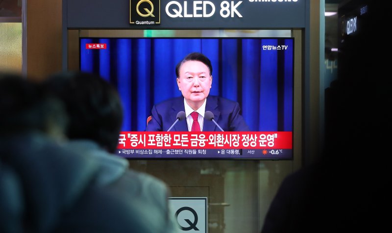 [서울=뉴시스] 김혜진 기자 = 윤석열 대통령이 비상계엄 해제를 선언한 지난해 12월4일 오전 서울역 대합실에서 시민들이 관련 뉴스를 보고 있다. 2024.12.04. jini@newsis.com
