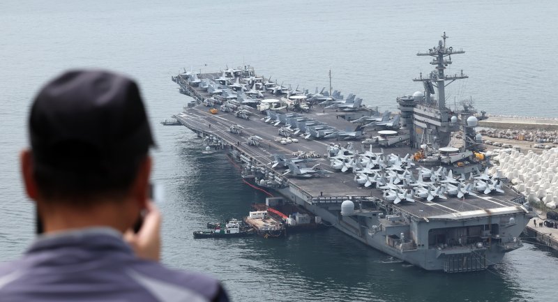 [부산=뉴시스] 하경민 기자 = 한국·미국·일본이 처음 실시하는 해상·수중·공중·사이버 등 다영역 군사훈련 '프리덤 에지'(Freedom Edge)에 참가하기 위해 미국 해군의 핵추진 항공모함 '시어도어 루스벨트'(CVN-71·10만t급)가 26일 부산 남구 해군작전사령부 부산작전기지에서 출항을 준비하는 모습을 한 시민이 지켜보고 있다. 2024.06.26. yulnetphoto@newsis.com