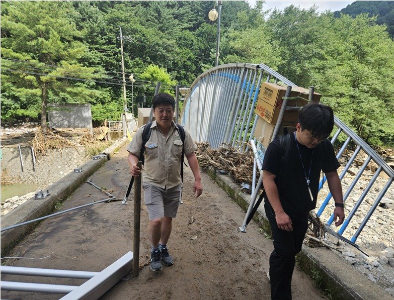 경기 가평군에서 집중호우로 고립된 마을 주민을 위해 연인산도립공원 직원들이 지게에 긴급 구호물품을 싣고 마을을 오가고 있는 모습(경기도 제공, 재판매 및 DB 금지)/뉴스1