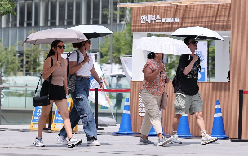 서울 종로구 광화문광장에서 외국인 관광객들이 양산을 쓴 채 발걸음을 옮기고 있다. /뉴스1 ⓒ News1 김성진 기자