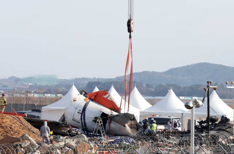 15일 오전 전남 무안국제공항 참사 현장에서 항공·철도사고 조사위원회 관계자들이 기체 잔해인 날개 부분을 수습하고 있다. 2025.1.15/뉴스1 ⓒ News1 박지현 기자