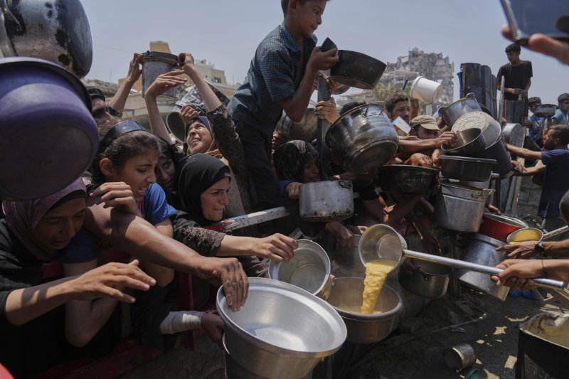 [가자시티=AP/뉴시스] 기아 위기가 고조되는 가자지구 가자시티에서 26일(현지 시간) 주민들이 힘겹게 식량을 받고 있다. 가자지구 휴전 협상이 교착에 빠진 가운데 이날 최소 25명이 공습과 총격으로 사망한 것으로 파악됐다. 2025.07.26.