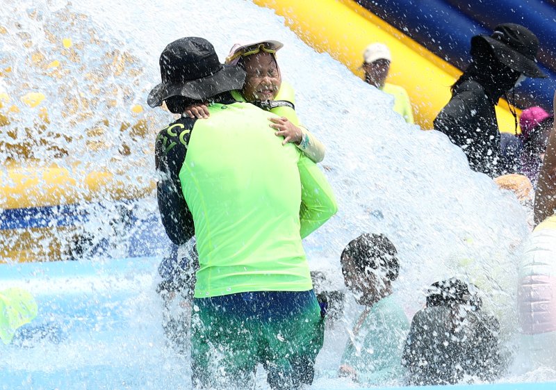 전국에 무더운 더위가 이어지는 26일 서울 성북구 숭덕초등학교에 마련된 성북문화바캉스 물놀이장에서 가족들이 즐거운 시간을 보내고 있다. 2025.7.26/뉴스1 ⓒ News1 김민지 기자