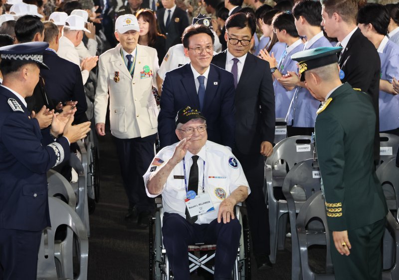 김민석 국무총리가 27일 경기도 고양시 킨텍스에서 열린 유엔군 참전의 날 기념식에서 참전용사의 휠체어를 직접 밀며 입장하고 있다. 공동취재단