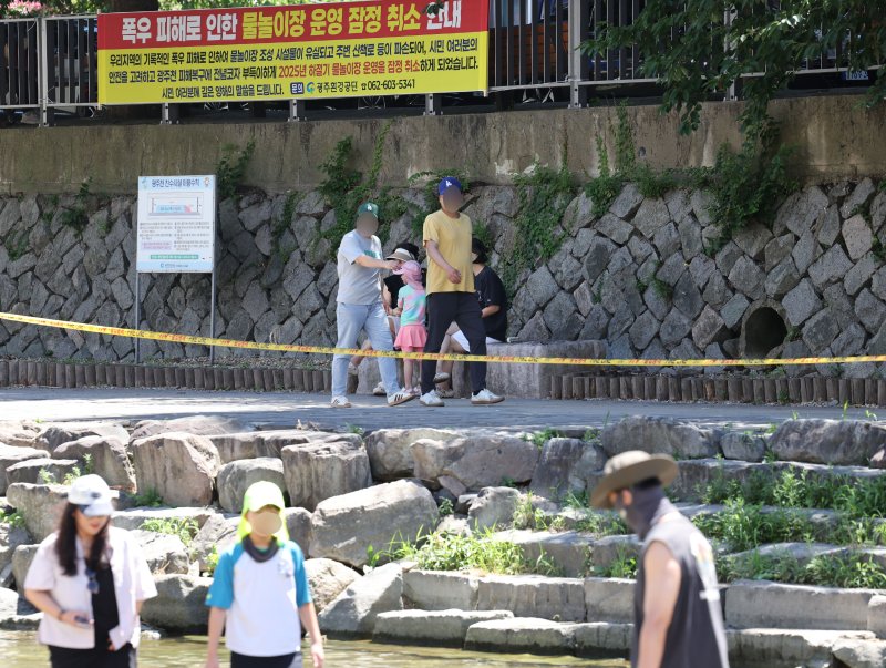 광주 동구 광주천 물놀이장에 '운영 잠정 취소'를 알리는 현수막이 걸려 있지만 시민들은 여전히 하천에서 물놀이를 즐기고 있다. 2025.7.27/뉴스1 ⓒ News1 박지현 기자