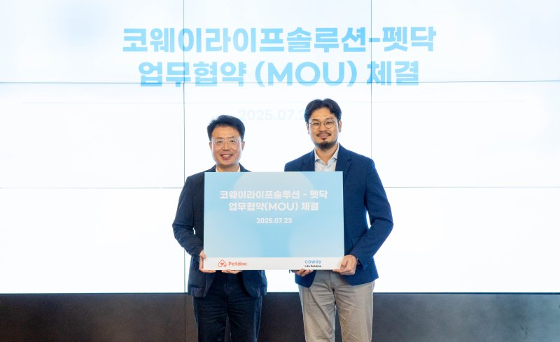 김명곤 코웨이라이프솔루션 대표(왼쪽)가 지난 23일 서울 구로 지타워 본사에서 열린 협약식에서 오태환 펫닥 대표와 기념 촬영을 하고 있다. 코웨이라이프솔루션 제공