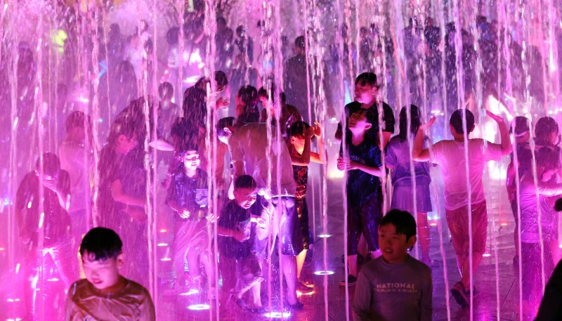 [부산=뉴시스] 하경민 기자 = 밤낮으로 푹푹 찌는 더위가 이어진 26일 밤 부산 사하구 다대포 꿈의 낙조분수를 찾은 어린이 등이 시원한 물줄기를 맞으며 더위를 식히고 있다. 2025.07.27. yulnetphoto@newsis.com