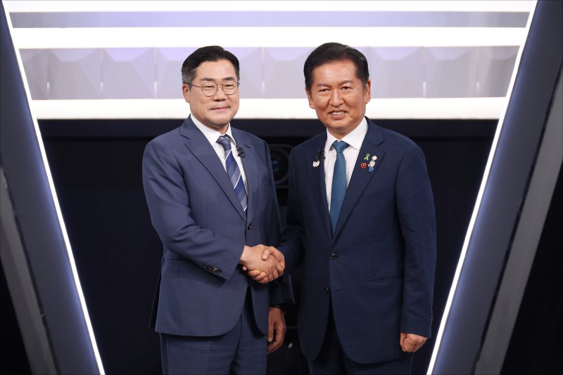 [서울=뉴시스] 국회사진기자단 = 박찬대, 정청래 더불어민주당 당대표 후보가 27일 오후 서울 여의도 KBS 신관 공개홀에서 TV토론회 시작 전 악수를 하며 포즈를 취하고 있다. 2025.07.27. photo@newsis.com