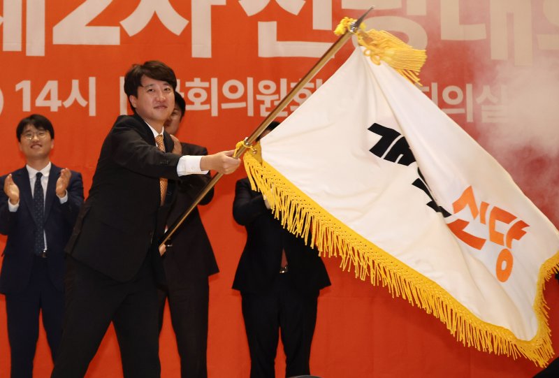 [서울=뉴시스] 김명년 기자 = 이준석 개혁신당 대표가 27일 오후 서울 여의도 국회 의원회관에서 열린 개혁신당 제2차 전당대회에서 당대표에 선출된 후 당기를 이양받아 흔들고 있다. 2025.07.27. kmn@newsis.conm