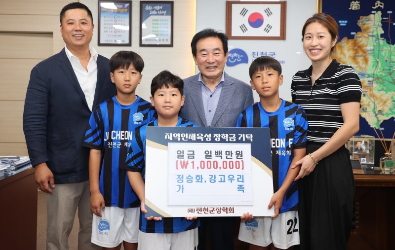 충북 진천 정승화 씨 가족이 재단법인 진천군장학회에 가스통에 모은 동전을 장학금으로 기탁하고 있다.(진천군 제공, 재판매 및 DB금지)/뉴스1