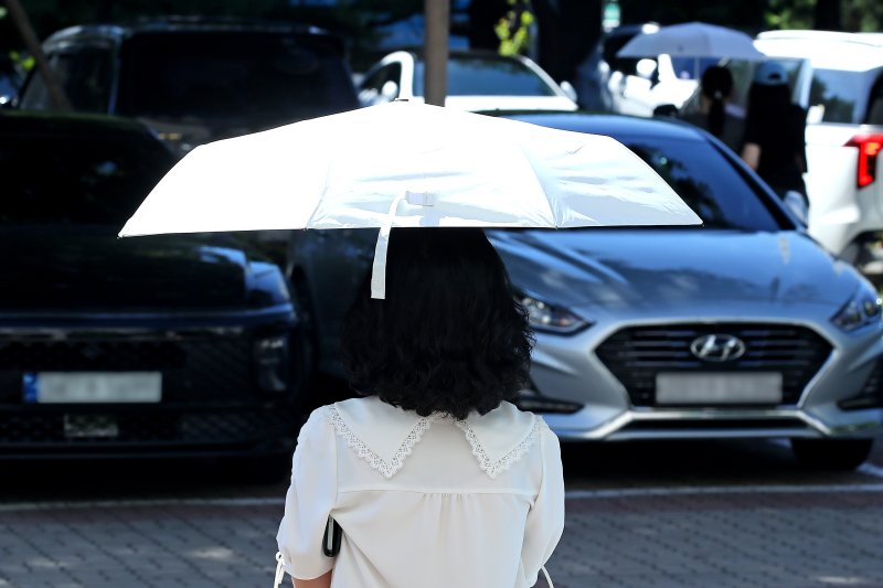폭염이 이어진 28일 오전 대구 달서구청 민원실에서 한 시민이 '양심양산'을 빌려 뙤약볕을 가린 채 청사를 나서고 있다. 2025.7.28/뉴스1 ⓒ News1 공정식 기자