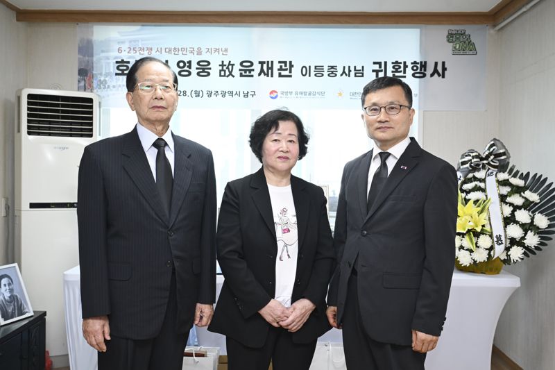 행사를 마치고 기념사진 촬영 중인 고 윤재관 이등중사의 유가족 내외와 이근원 국방부 유해발굴감식단장(왼쪽부터 윤금순 씨의 남편 김송오 씨(76세), 고인의 딸인 윤금순 씨(74세), 이근원 국방부유해발굴감식단장). 국방부 제공