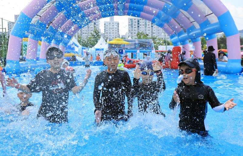 28일 오전 서울 강남구 일원에코파크 내 족구장에 마련된 물놀이장에서 어린이들이 물장구를 치며 무더위를 식히고 있다. 2025.7.28/뉴스1 ⓒ News1 김진환 기자