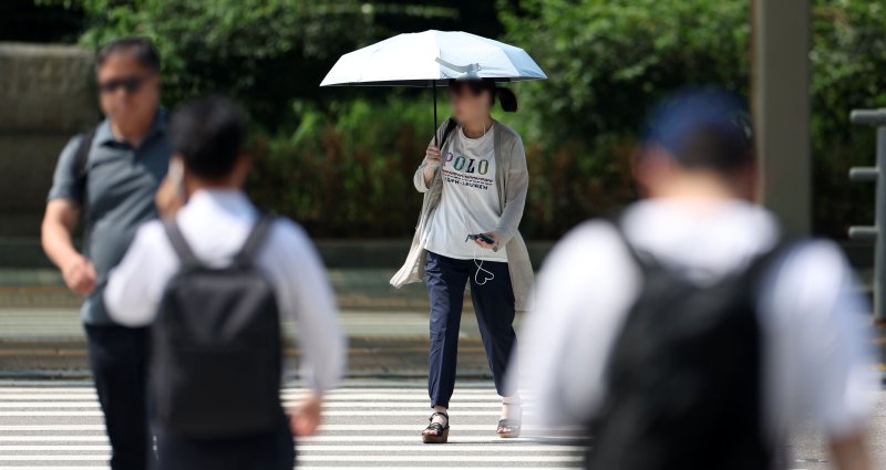 [서울=뉴시스] 김선웅 기자 = 서울 낮 최고기온이 37도를 기록하는 등 전국 대부분 지역에 폭염이 기승을 부린 28일 오후 서울 여의도에서 한 시민이 양산으로 햇빛을 가리고 있다. 2025.07.28. mangusta@newsis.com