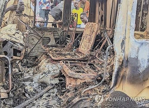 민주콩고 코만다시에서 IS 연계 무장단체 공격으로 불에 탄 차량 들여다보는 주민들 (출처=연합뉴스)