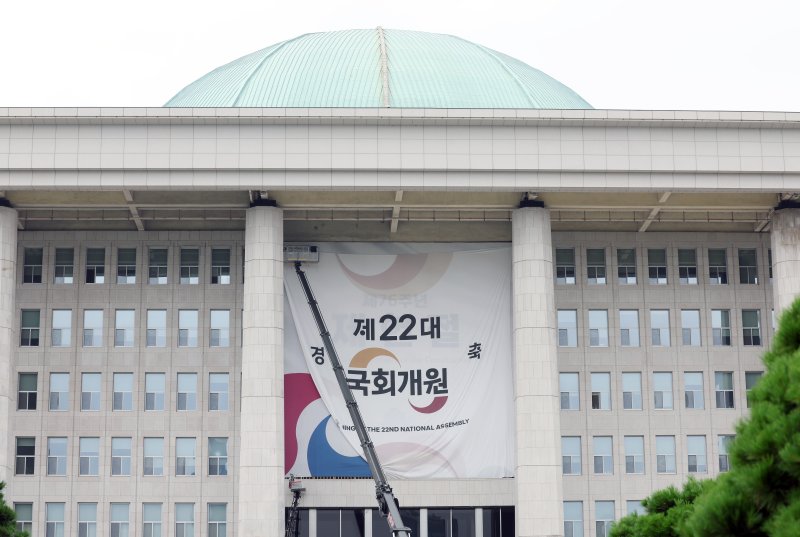 [서울=뉴시스] 고승민 기자 = 제22대 국회가 여야 대립으로 평행선을 유지하며 개원식마저 연기되는 등 정국이 급랭하고 있는 7일 서울 여의도 국회에서 제22대 국회 개원을 축하하는 대형 현수막이 철거되고 있다. 2024.07.07. kkssmm99@newsis.com