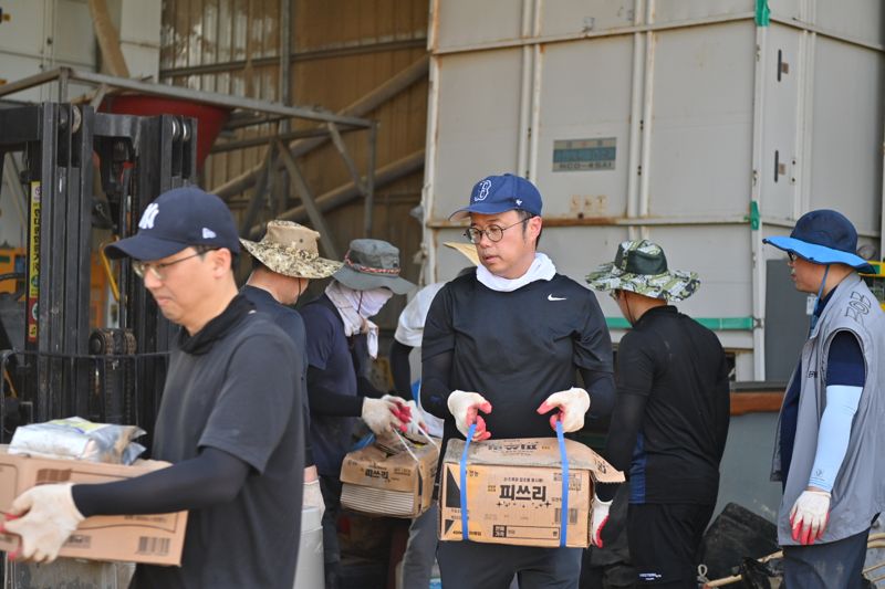 충남도 대변인실 직원들이 29일 최근 폭우 피해를 입은 예산군 오가면 체리 농가에서 침수됐던 농사 용품들을 정리하며 복구에 구슬땀을 흘리고 있다.