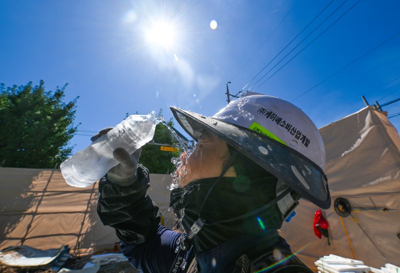 [광주=뉴시스] 이영주 기자 = 광주지역 최고기온이 36도로 예보된 29일 오전 광주 북구 옛 중흥2동 행정복지센터 철거현장에서 노동자들이 휴식시간을 이용해 물을 마시며 더위를 쫓고 있다. 광주지역에는 지난 20일 이후 현재까지 열흘 동안 폭염특보가 이어지고 있다. 2025.07.29. leeyj2578@newsis.com