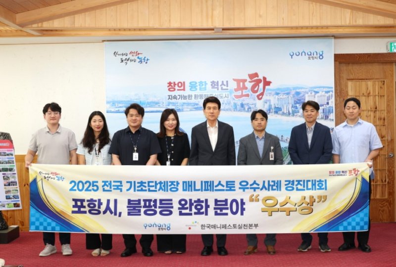 [포항=뉴시스] 송종욱 기자 = '제15회 2025 전국 기초단체장 매니페스토 우수 사례 경진대회'가 최근 경국대학교 안동캠퍼스에서 열린 가운데 포항형 공공앱 '타보소'가 전국 기초단체장 매니페스토 우수 사례 '우수상'을 받았다. 사진은 29일 시청 대외협력실에서 이강덕 시장과 직원들이 매니페스토 우수 사례 경진대회 수상을 기념해 사진을 찍는 모습. (사진=포항시 제공) 2025.07.29. photo@newsis.com