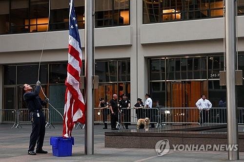 뉴욕 총기 난사 건물 앞에서 조기 게양하는 남성 (출처=연합뉴스)