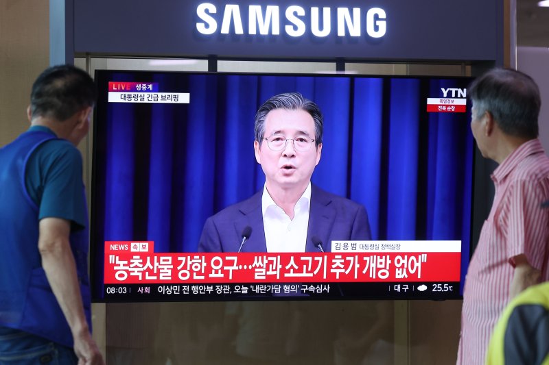 [서울=뉴시스] 권창회 기자 =미국과 관세 협상이 15%로 타결된 31일 오전 서울 용산구 서울역에서 시민들이 김용범 정책실장의 미국과 관세 협상 타결 관련 브리핑을 시청하고 있다. 2025.07.31. kch0523@newsis.com