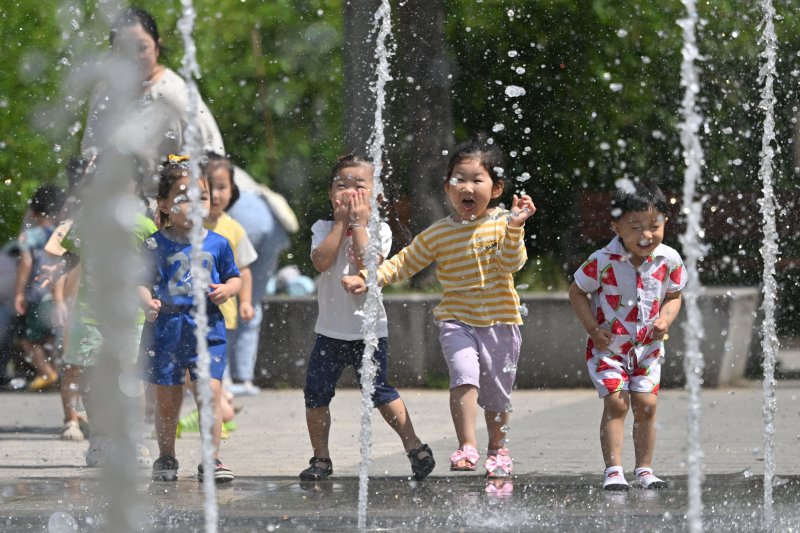 [광주=뉴시스] 이영주 기자 = 광주지역에 폭염특보가 엿새째 이어지고 있는 2일 오전 광주 북구 신용근린공원 바닥분수에서 광주 북구 국공립아이큰숲어린이집 소속 원아들이 물놀이를 즐기고 있다. 2025.07.02. leeyj2578@newsis.com