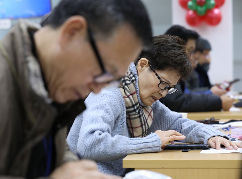 [서울=뉴시스] 박미소 수습기자 = 2018년 서울시 금천구청 전산교육실에서 열린 ‘어르신 스마트 과거시험’에 참여한 어르신 응시생들이 스마트폰으로 문제를 풀고 있다. 2018.12.17. misocamera@newsis.com **기사 내용과 관련 없습니다**