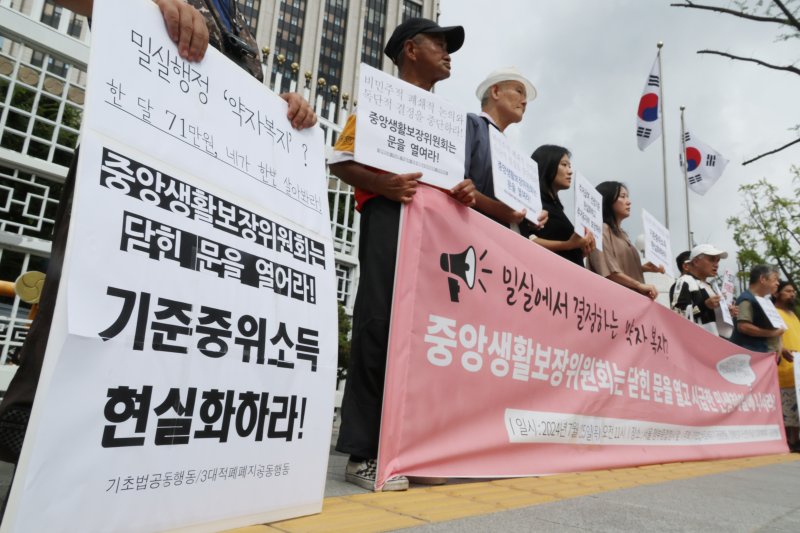 [서울=뉴시스] 김명원 기자 = 기초법바로세우기 공동행동 등 참석자들이 지난해 7월 25일 오전 서울 종로구 정부서울청사 앞에서 정부 중앙생활보장위원회에 기준중위소득 현실화와 부양의무자기준 완전 폐지를 요구하는 민중생활보장위원회 기자회견을 하고 있다. 2024.07.25. kmx1105@newsis.com