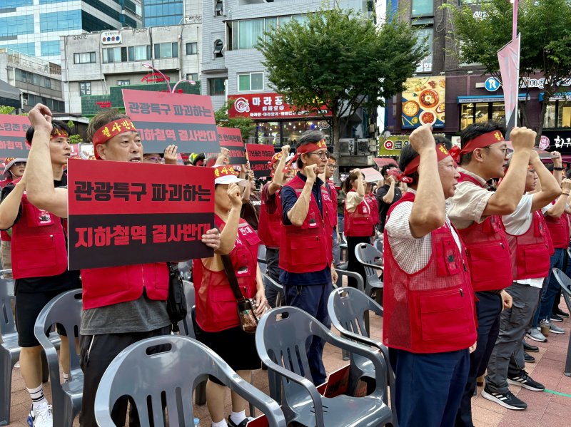 [서울=뉴시스] 한이재 기자 = 31일 오후 서울 마포구 레드로드 내에서 홍대상인회와 대장홍대선 레드로드역사 반대 비상대책위원회가 대장홍대선 레드로드역사 반대 기자회견을 열었다. 참가자들이 구호를 외치며 손을 드는 모습이다. 2025.07.31. nowone@newsis.com