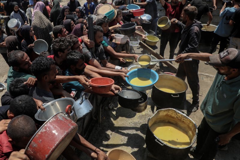 [가자시티=신화/뉴시스] 지난 24일 가자 지구 가자시티 자선 급식소에서 팔레스타인 주민들이 구호 음식을 받고 있다. 2025.07.25.
