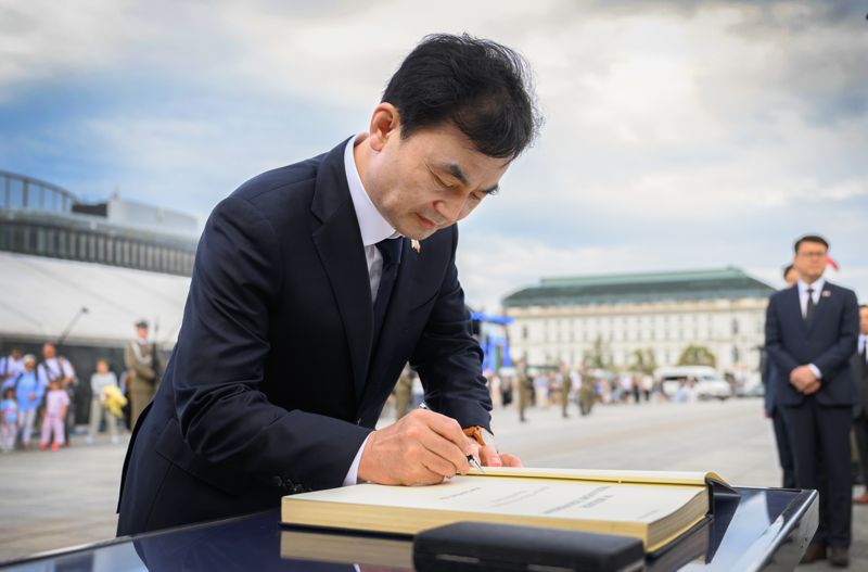 폴란드를 방문 중인 안규백 국방부장관이 31일(현지시간) 오후 폴란드 바르샤바 샤스키공원 무명용사의 묘를 찾아 태극기 모양의 조화를 헌화후 방명록에 글을 적고 있다. 국방부 제공