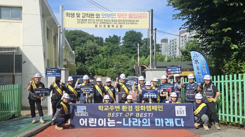 동문건설이 지난 7월 23일 경기도 파주시에서 '학교 주변 환경정화의 날' 행사를 진행한 후 기념촬영을 하는 모습. 동문건설 제공