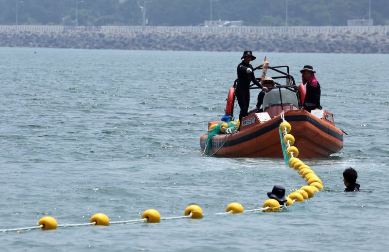 [부산=뉴시스] 하경민 기자 = 부산 수영구청 관계자들이 27일 광안리해수욕장에서 선박을 동원, 해안선으로부터 바다 방향 100m 구간에 해파리 유입 방지 그물망을 설치하고 있다. 광안리 등 부산 7개 해수욕장은 오는 7월1일 전면 개장하며, 수영구는 올해 처음으로 피서객 해파리 쏘임 피해를 막기 위해 그물망을 설치했다. 2025.06.27. yulnetphoto@newsis.com