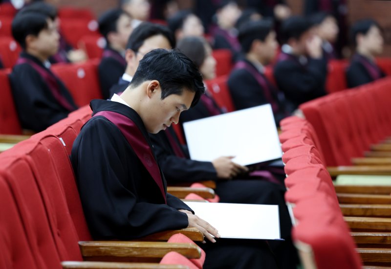 [과천=뉴시스] 김진아 기자 = 1일 경기 정부과천청사 법무부에서 열린 2025 하반기 신임검사 임관식에서 한 신임 검사가 임명장을 보고 있다. 2025.08.01. bluesoda@newsis.com