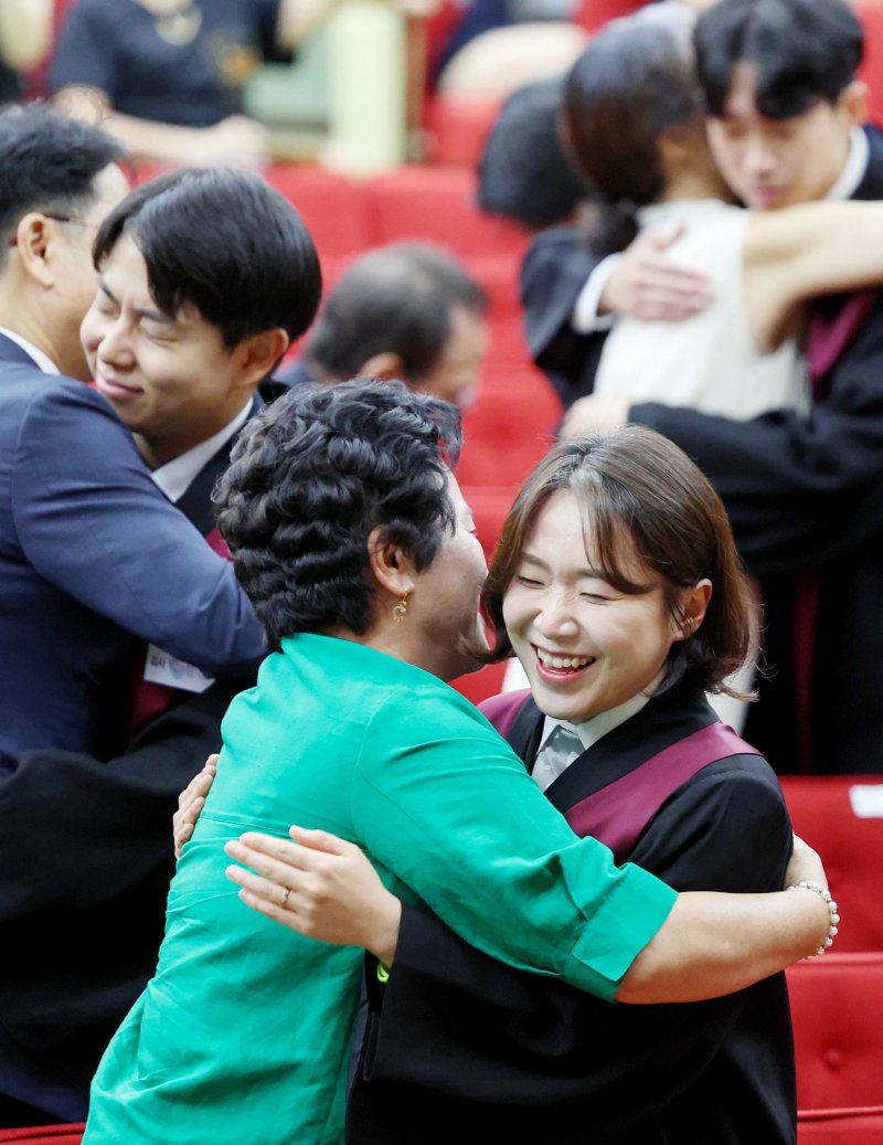 [과천=뉴시스] 김진아 기자 = 1일 경기 정부과천청사 법무부에서 열린 2025 하반기 신임검사 임관식에서 신임 검사들이 부모님과 포옹을 하고 있다. 2025.08.01. bluesoda@newsis.com