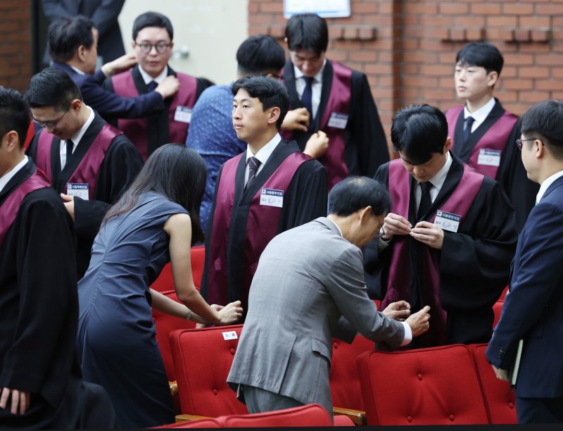 [과천=뉴시스] 김진아 기자 = 1일 경기 정부과천청사 법무부에서 열린 2025 하반기 신임검사 임관식에서 부모님들이 신임 검사들에게 법복을 입혀주고 있다. 2025.08.01. bluesoda@newsis.com