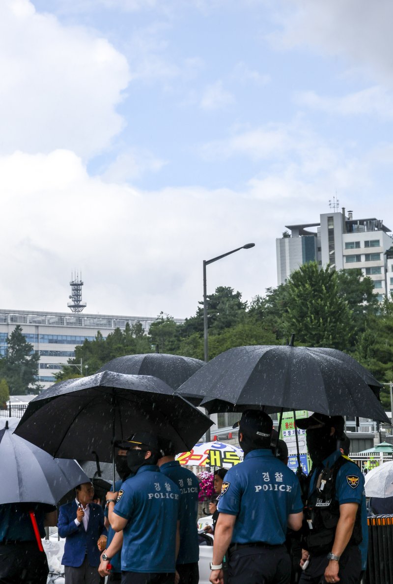 [서울=뉴시스] 조성우 기자 = 1일 서울 용산구 전쟁기념관 인근에서 내린 소나기에 경찰들이 우산을 쓰고 있다. 2025.07.01. xconfind@newsis.com