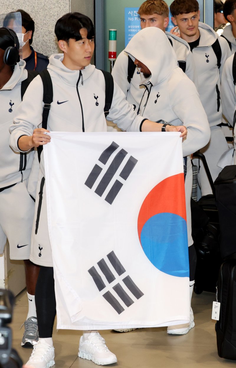 잉글랜드 프리미어리그(EPL) 토트넘 홋스퍼의 손흥민이 1일 오후 프리 시즌 투어를 위해 인천공항에 도착해 기념 촬영 후 태극기를 접고 있다. 2025.8.1/뉴스1 ⓒ News1 권현진 기자