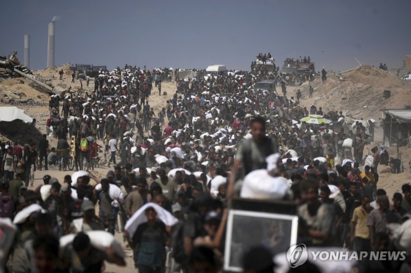 구호 식량 받아 옮기는 가자지구 주민들 (출처=연합뉴스)