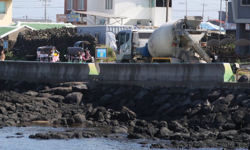 지난 1일 오전 제주에서 운행 중인 이륜차 뒤로 레미콘차량이 지나가고 있다.