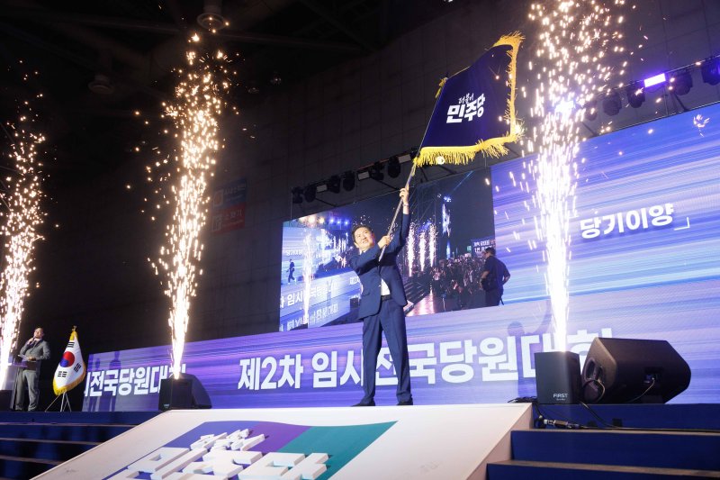 정청래 더불어민주당 신임 당대표가 2일 경기 고양시 킨텍스에서 열린 제2차 임시전국당원대회에서 당기를 흔들고 있다. (공동취재) 2025.8.2/뉴스1 ⓒ News1 유승관 기자