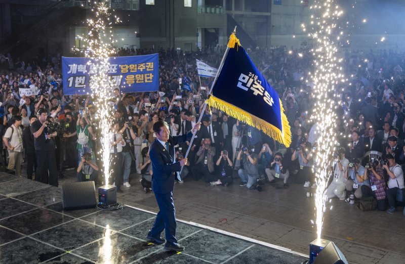 정청래 더불어민주당 신임 당대표가 2일 경기 고양시 킨텍스에서 열린 제2차 임시전국당원대회에서 당기를 흔들고 있다. (공동취재) 2025.8.2/뉴스1 ⓒ News1 유승관 기자