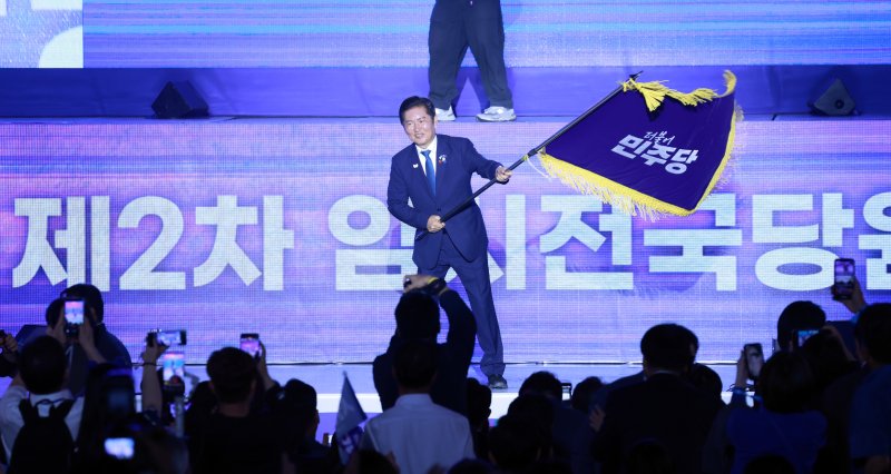 [고양=뉴시스] 고승민 기자 = 정청래 신임 더불어민주당 대표가 2일 경기 고양 킨텍스에서 열린 더불어민주당 제2차 임시전국당원대회에서 당기를 흔들고 있다. 2025.08.02. kkssmm99@newsis.com