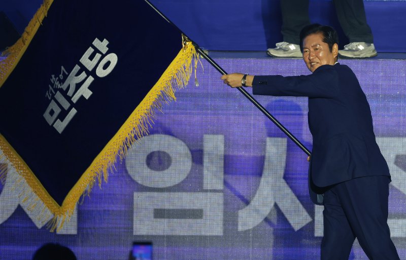 정청래 더불어민주당 신임 당대표가 2일 경기 고양시 킨텍스에서 열린 제2차 임시전국당원대회에서 당기를 흔들고 있다. (공동취재) 2025.8.2/뉴스1 ⓒ News1 유승관 기자