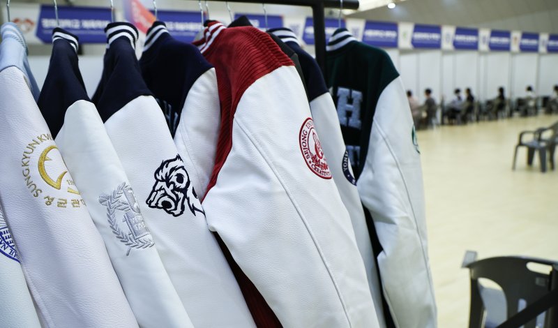 [서울=뉴시스] 최진석 기자 = 29일 서울 강남구 일원에코파크 에코센터에서 열린 '2025 강남구 진로진학 박람회'를 찾은 학생과 학부모들이 각 대학 부스에서 대학입시 상담받는 인근에 각 대학의 로고가 새겨진 점퍼가 보이고 있다. 2025.07.29. myjs@newsis.com