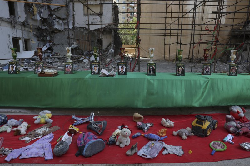 [테헤란=AP/뉴시스]지난 6월13일 이스라엘의 이란 수도 테헤란 거주 지역 공습으로 숨진 어린이들의 사진이 전시돼 있다. 앞에는 어린이들의 인형과 책가방 등 유품들이 놓여 있다. 2025.08.03.