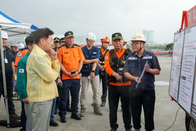 [제주=뉴시스] 오영훈 제주지사가 3일 오후 가스 누출 사고가 발생한 제주시 도두동 공공하수처리장 공사장에서 현장 브리핑을 청취하고 있다. (사진=제주도 제공) 2025.08.03. photo@newsis.com